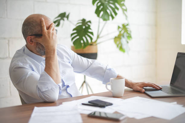 istock mature adult man working from office ( with laptop,paperwork, video conference) 1338122344