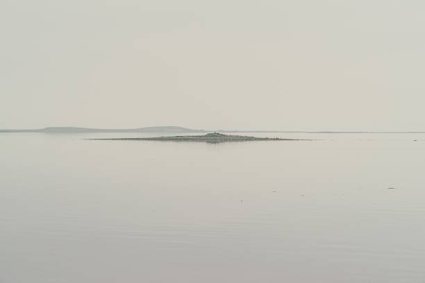 穏やかで霧に囲まれた海の島の輪郭 - drumlin ストックフォトと画像