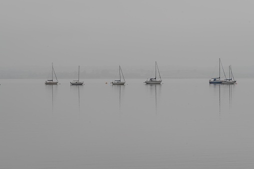Yachts moored on calm waters of Strangford Lough, County Down (Norther Ireland) on a misty day.