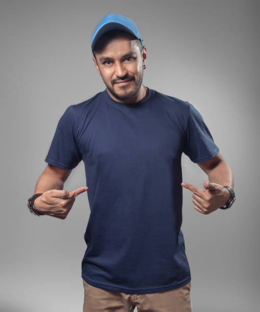 mockup of male hispanic model pointing his navy blue t-shirt - fashion men fashion model male imagens e fotografias de stock