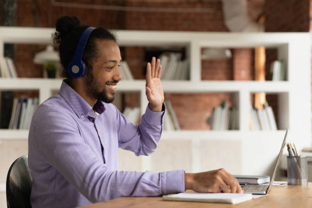 African student guy greeting online tutor starts class through videocall