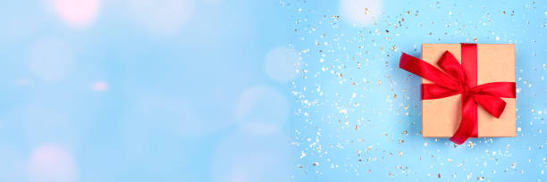 istock Festive banner with gift box on ligth blue background with bokeh lights around with copy space. Flat lay style for Christmas, New Year, birthday celebration or holidays sale concept 1338134457