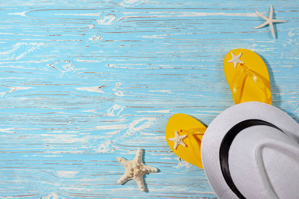 istock yellow rubber flip flops, white beach hat, starfish on a blue wooden background 1338135124