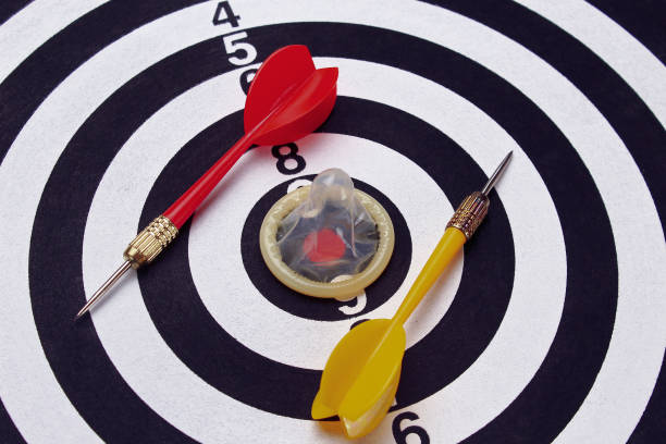 istock Unpacked condom on the background of a dartboard target darts 1338145284
