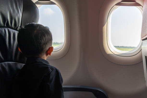 istock Little boy looking out of airplane 1338148396