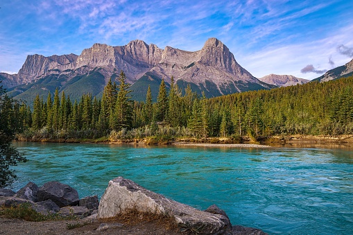 A blue sky over mountains and river in Canmore in the summertime.