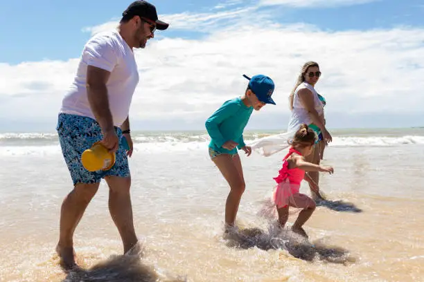 Family playing on the beach on a sunny day in Brazil