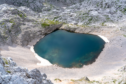 Top view of Upper Krisko Lake in Julian Alps is the highest lying Slovenian lake (2,154 meters), measures about 80 times 80 meters and is little above  Pogacnik cottage.