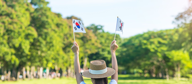Mujer sosteniendo la bandera de Corea en el fondo de la naturaleza. Fundación Nacional, Gaecheonjeol, fiesta pública de la nación, Día de la Liberación Nacional de Corea y conceptos de celebración feliz photo