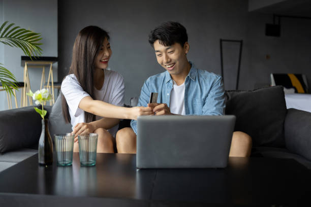 istock Young couples use laptops to shop online at home 1338181917