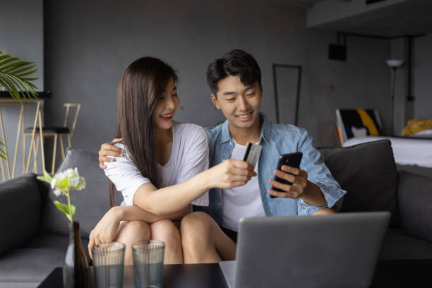 istock Young couples use laptops to shop online at home 1338181938