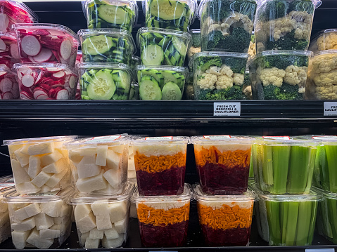 Freshly cut veggies in plastic containers on display at grocery store