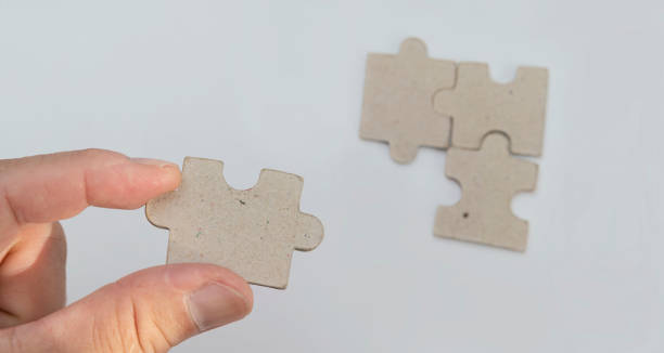istock Pieces of jigsaw puzzle in man's hands 1338184507
