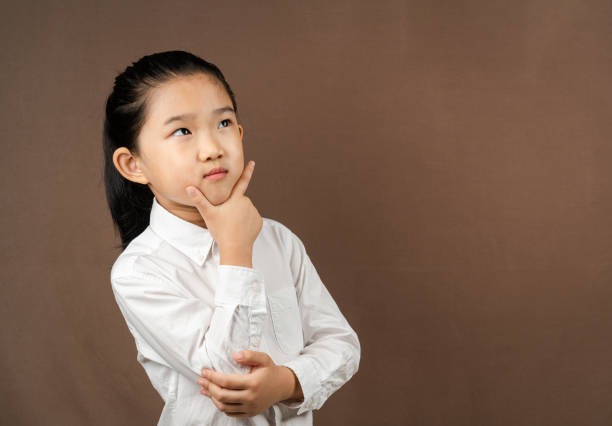 istock Little Girl Think on Brown Background 1338185106