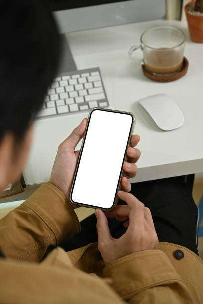 istock Young man sitting at workplace and using smart phone. 1338191371