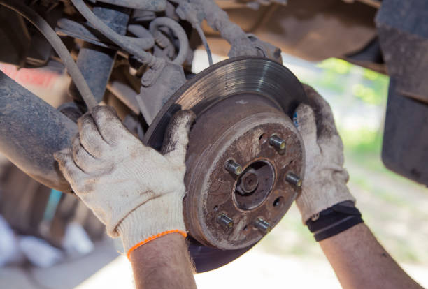 istock The man's hands remove the worn brake disc from the rear wheel hub. 1338195383