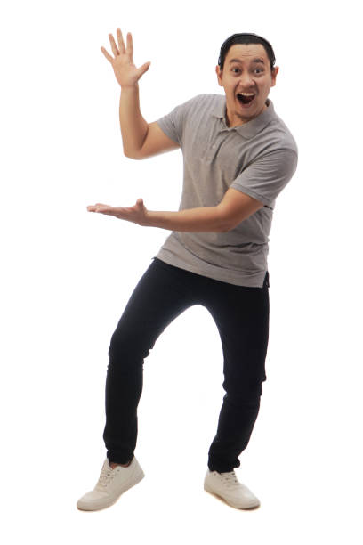 istock Asian man shocked surprised happy cheerful expression presenting pointing to side with copy space. Full body portrait isolated cut out 1338195534