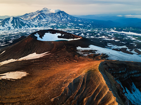 Crater of Gorely volcano and Mutnovsky volcano in the background. Kamchatka peninsula, Russia. Beautiful landscape at sunrise.
