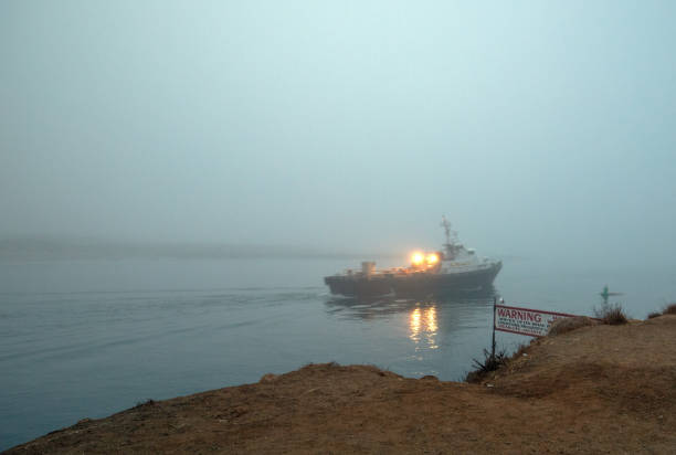 чартерное рыболовное судно покидает гавань залива морро в утреннем тумане на центральном побережье калифорнии сша - inversion layer стоковые фото и изображения