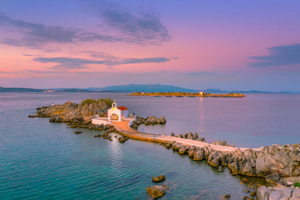 pequena igreja de agios isidoros no mar sobre as rochas, ilha chios, grécia. - chios island - fotografias e filmes do acervo