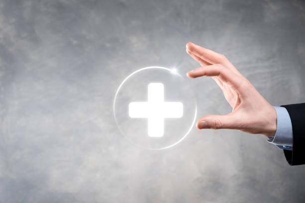 istock Businessman hold virtual plus medical network connection icons. Covid-19 pandemic develop people awareness and spread attention on their healthcare. 1338209218