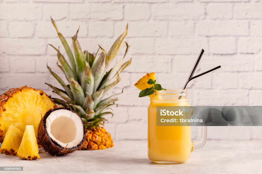 Tropical pineapple smoothie in a mason jar Tropical pineapple smoothie in a mason jar, selective focus. Pina Colada Stock Photo