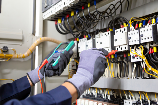 Ingeniero electricista prueba instalaciones eléctricas y cables en el sistema de protección de relés. Ajuste de esquema de automatización y control de equipos eléctricos. photo