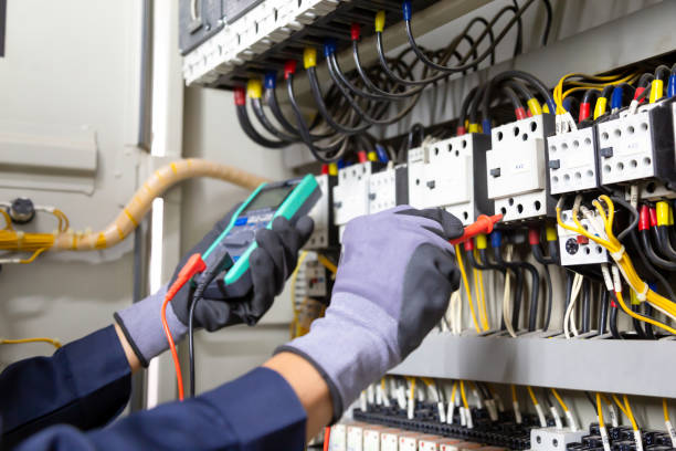 electrician engineer tests electrical installations and wires on relay protection system. adjustment of scheme of automation and control of electrical equipment. - confined space safety danger sign imagens e fotografias de stock