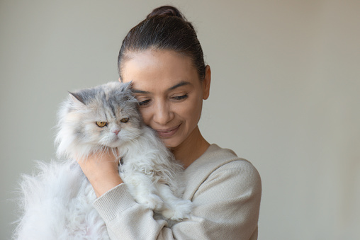 A woman is hugging her cat.