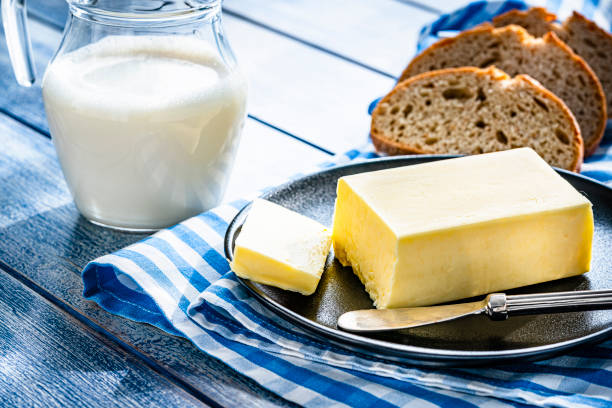 bâton de beurre, pot de lait et pain sur table bleue - butter bread breakfast table photos et images de collection