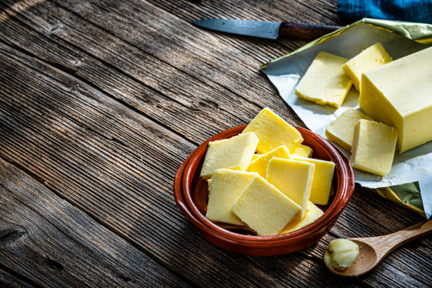 istock Butter slices in a bowl on wooden table. Copy space 1338222213