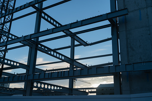 Construction steel framework in silhouette against blue sky. at sunrise.