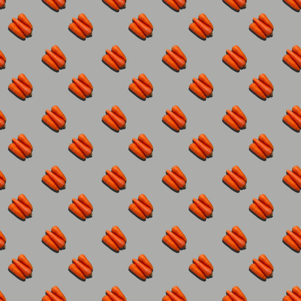 istock Seamless pattern from fresh juicy carrots on a uniform colored background. 1338236173