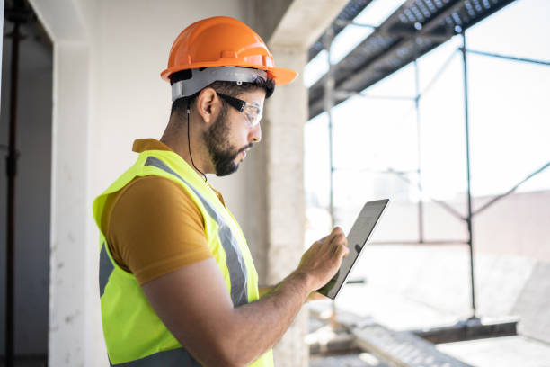 junger ingenieur mit digitalem tablet auf der baustelle - building contractor computer internet construction worker stock-fotos und bilder