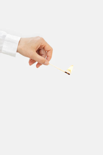 woman hand holds lit match. wooden matchstick is burning. fire hazard concept. - fire match women flame imagens e fotografias de stock