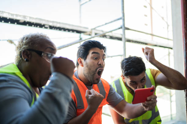 istock Construction workers watching sports match on smartphone in a construction site 1338247144