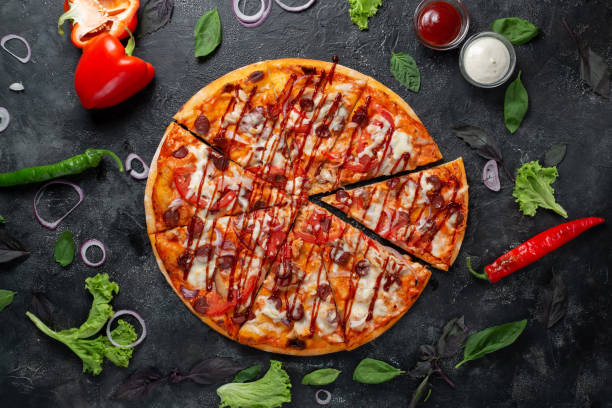 istock Rustic pizza on a dark background with vegetables, peppers, mozzarella and basil. Top view on dark stone table 1338251145