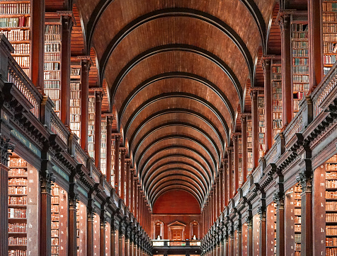 View of the library gallery of Trinity College, where the Book of Kells is kept. The Book of Kells (Trinity College Dublin) contains the four Gospels in Latin based on the Vulgate text which St Jerome completed in 384AD, intermixed with readings from the earlier Old Latin translation.