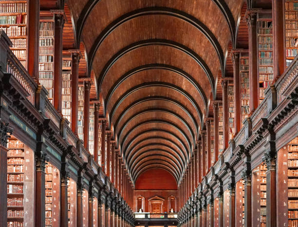The Book of Kells, Trinity College, Dublin View of the library gallery of Trinity College, where the Book of Kells is kept. The Book of Kells (Trinity College Dublin) contains the four Gospels in Latin based on the Vulgate text which St Jerome completed in 384AD, intermixed with readings from the earlier Old Latin translation. trinity college library stock pictures, royalty-free photos & images