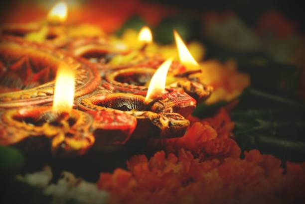 indian festival diwali, navratri, celebrations vertical picture by lighting colourful diya lamps lights with  marigold flowers and green leaves - indian god fotos imagens e fotografias de stock