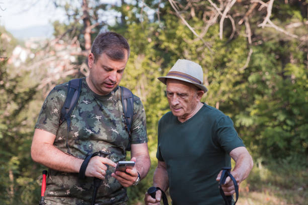 father and son seeking online maps after getting lost on a hike - explorer tourist frowning men imagens e fotografias de stock