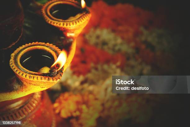 Diwali Celebrations With Diyas Lighted In A Terracotta Stand With Pooja Flowers Stock Photo - Download Image Now