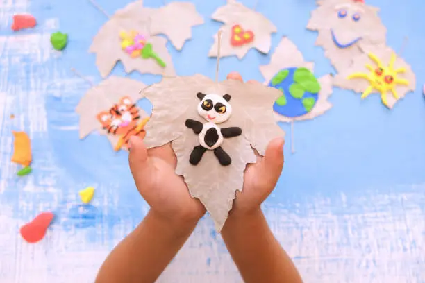 Child made panda from plasticine. Protection of environment, Save our planet and animals. Ecology concept. Concept of art learning and education , save world, world animal day