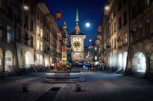 rue kramgasse la nuit avec zytglogge et fontaine zähringen - berne, suisse - flag bearer photos et images de collection