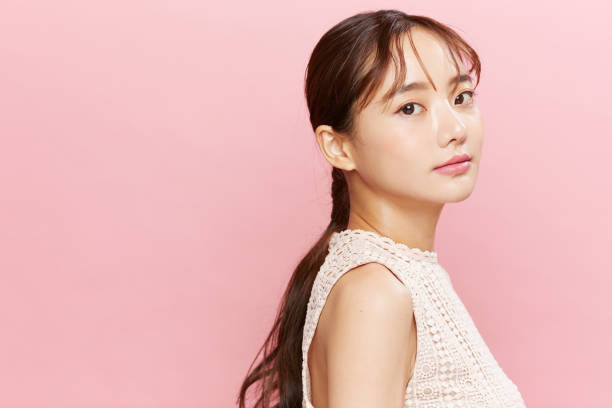 retrato de belleza de una joven asiática con vestido sobre fondo rosa - attractive female indoors lifestyles clean fotografías e imágenes de stock