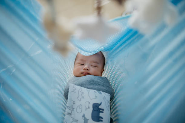 Image of an Asian baby boy sleeping in hanging cradle