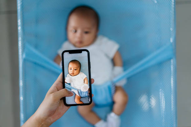 frau, die ihr baby mit dem smartphone fotografieren - fotohandy fotos stock-fotos und bilder