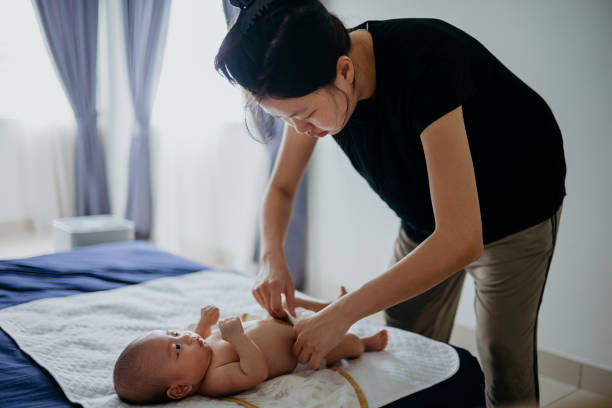 istock Asian mother changing diaper for her baby on bed 1338263050