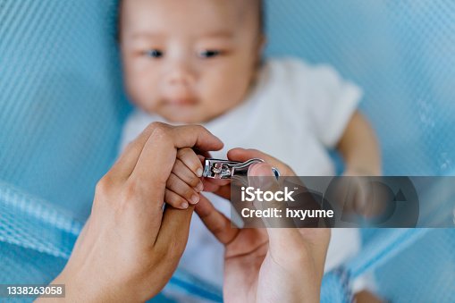 istock Mother clipping nail of her baby at home 1338263058