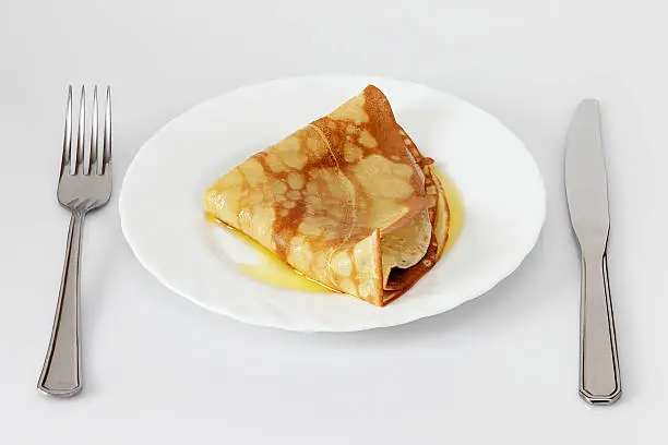 Pancake, folded on a plate with butter